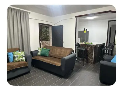 a living room with a couch and a table at Apartamento estadio CUSCATLAN in San Salvador