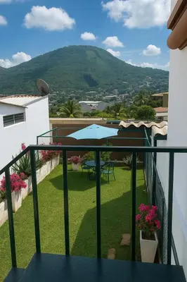 a balcony with a view of a table and umbrella at Suite Linda Vista Descanso y Naturaleza in San Marcos