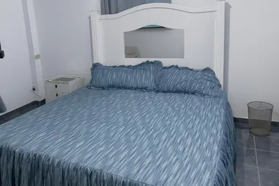 a bedroom with a bed with a blue comforter at Suite Linda Vista Descanso y Naturaleza in San Marcos