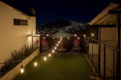 a patio with lights on a fence at night at Suite Linda Vista Descanso y Naturaleza in San Marcos