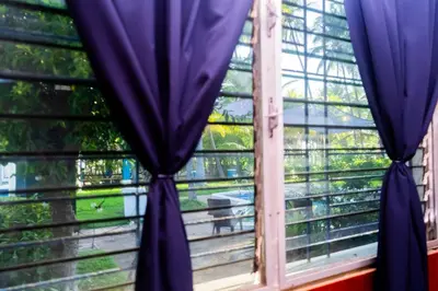 a window with blue curtains in a room at Rancho Mayayi Beach house in San Miguel