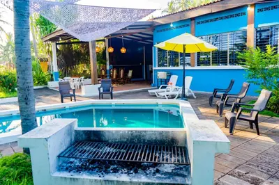 a swimming pool with chairs and a table and an umbrella at Rancho Mayayi Beach house in San Miguel