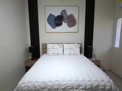 a bedroom with a white bed with two night stands at The Diamond Hotel San Benito in San Salvador