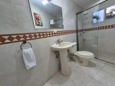 a bathroom with a toilet and a sink and a shower at The Diamond Hotel San Benito in San Salvador