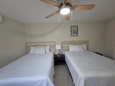 a bedroom with two beds and a ceiling fan at The Diamond Hotel San Benito in San Salvador