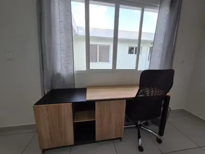 a desk with a chair in front of a window at The Diamond Hotel San Benito in San Salvador