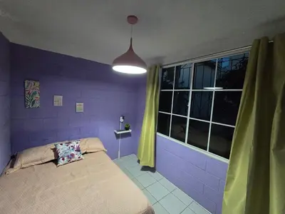 a purple bedroom with a bed and a window at the best private apartmet in santa ana for your trip with excelente location in Santa Ana