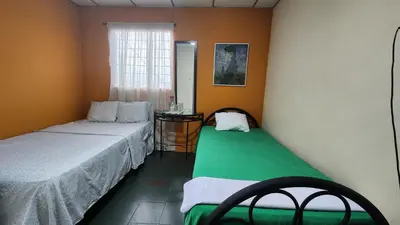 a small room with two beds and a window at Casa en Altos del Cerro in Soyapango