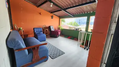 a living room with a blue couch and chairs at Casa en Altos del Cerro in Soyapango