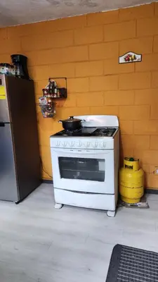 a kitchen with a white stove with a pot on it at Casa en Altos del Cerro in Soyapango
