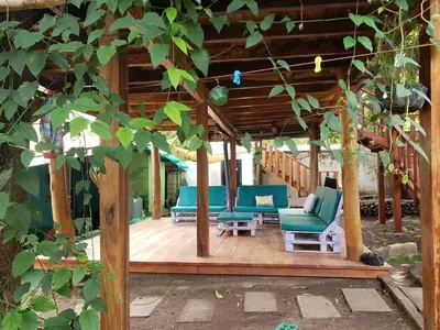 a porch with blue chairs and a wooden deck at Surf House