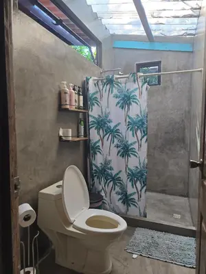 a bathroom with a shower with a toilet and a shower curtain at Surf House