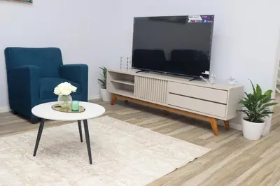 a living room with a tv and two blue chairs and a table at Casa Veraneras in Santa Ana