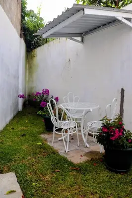 a patio with a table and chairs and flowers at Casa Veraneras in Santa Ana