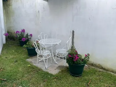 a table and chairs next to a wall with flowers at Casa Veraneras in Santa Ana