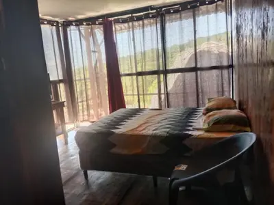 a bed in a room with a large window at K-Chimbón Zonte playa! Best place view! in El Zonte