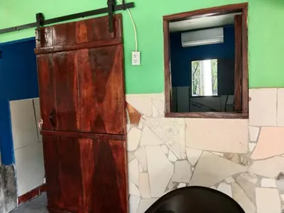 a bathroom with a wooden door and a mirror at K-Chimbón Zonte playa! Best place view! in El Zonte