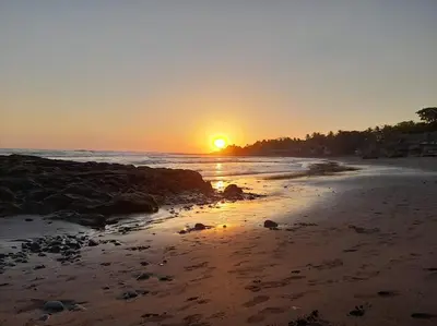 a sunset on a beach with the sun setting at K-Chimbón Zonte playa! Best place view! in El Zonte