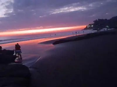 a person standing on a beach at sunset at K-Chimbón Zonte playa! Best place view! in El Zonte