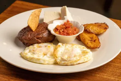 a plate of breakfast food with eggs potatoes and salsa at Suite sencilla