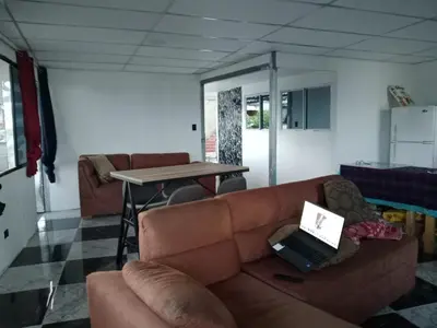 a living room with a couch and a table with a laptop at Habitaciones Clásica en lo mejor de SS city in San Salvador