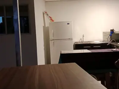 a kitchen with a white refrigerator and a table at Habitaciones Clásica en lo mejor de SS city in San Salvador