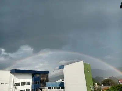 a rainbow in the sky over a building at Habitaciones Clásica en lo mejor de SS city in San Salvador