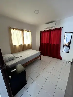 a bedroom with a bed and a red curtain at BuenaMar Malibu Beach in Sonsonate