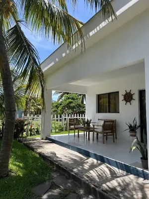 a patio of a house with a table and chairs at BuenaMar Malibu Beach in Sonsonate