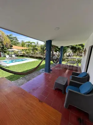 a patio with a hammock and a swimming pool at BuenaMar Malibu Beach in Sonsonate