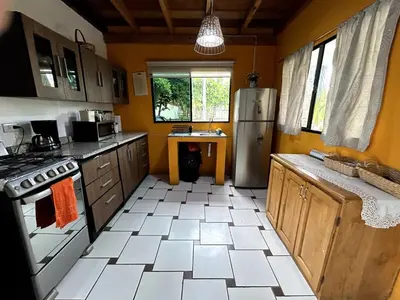 a kitchen with a refrigerator and a white tile floor at BuenaMar Malibu Beach in Sonsonate