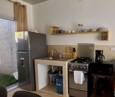 a kitchen with a stainless steel refrigerator and a sink at Casa Ecoterra in Comecayo
