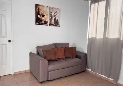 a couch with pillows on it in a living room at Colibri de Montaña in Ahuachapán