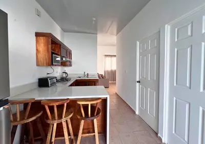 a kitchen with a counter and stools in a room at Colibri de Montaña in Ahuachapán