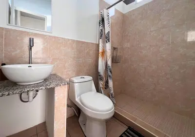 a bathroom with a toilet and a sink and a shower at Colibri de Montaña in Ahuachapán