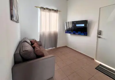 a living room with a couch and a flat screen tv at Colibri de Montaña in Ahuachapán