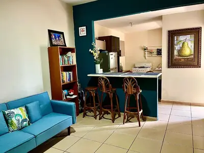 a living room with a blue couch and a kitchen at Apartment near to the best San Salvador areas in San Salvador