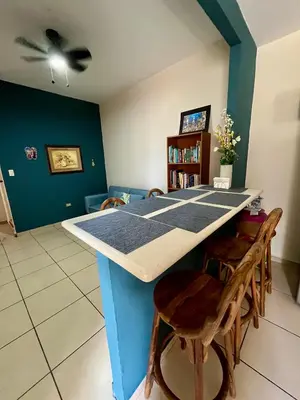 a kitchen with a blue island with a table and chairs at Apartment near to the best San Salvador areas in San Salvador