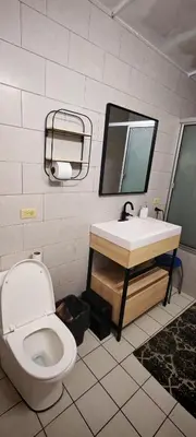 a bathroom with a toilet and a sink and a mirror at Habitación Lomas de San Francisco in San Salvador