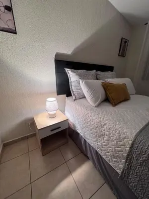 a bedroom with a bed with a nightstand next to it at Casa Bella Vista in Apopa