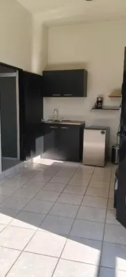 a kitchen with black cabinets and a tile floor at Hotel Sweet Dreams in La Unión