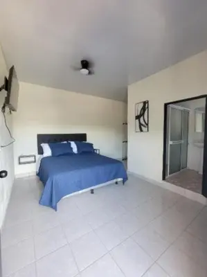 a bedroom with a blue bed and a mirror at Hotel Sweet Dreams in La Unión