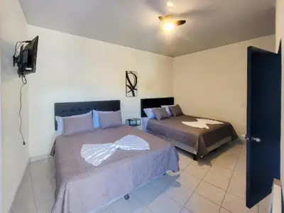 a bedroom with two beds and a television in it at Hotel Sweet Dreams in La Unión