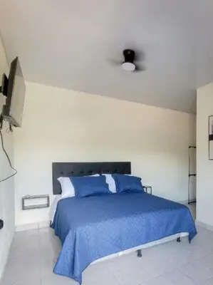 a bedroom with a bed with a blue blanket at Hotel Sweet Dreams in La Unión