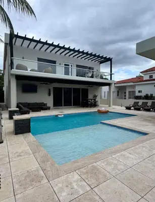a house with a swimming pool in front of a house at Casa Cristal in San Luis La Herradura