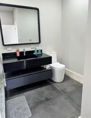 a bathroom with a sink and a toilet and a mirror at Casa Cristal in San Luis La Herradura