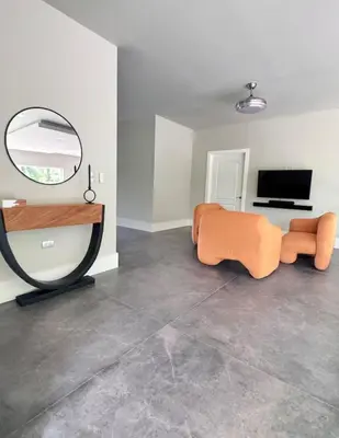 a living room with an orange couch and a mirror at Casa Cristal in San Luis La Herradura