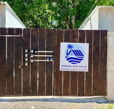 a wooden fence with a sign on it at Sunzal Loft, ISA Ecovilla Surfing in El Sunzal