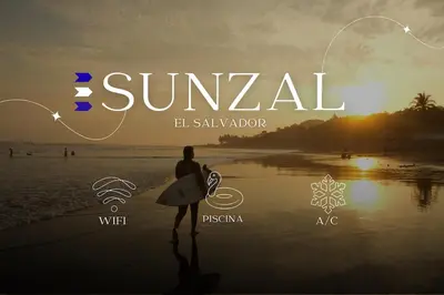 a man walking on the beach with a surfboard at Sunzal Loft, ISA Ecovilla Surfing in El Sunzal