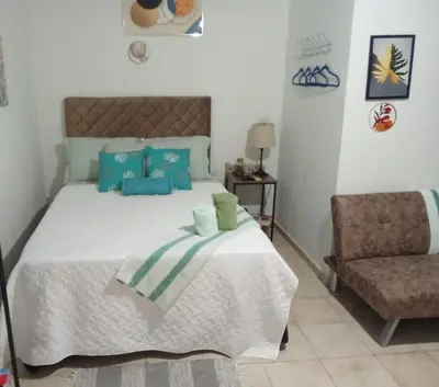 a bedroom with a bed with blue pillows and a chair at Sunzal Loft, ISA Ecovilla Surfing in El Sunzal